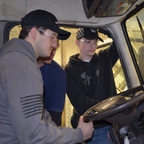 American Diesel Training Center participants working inside of a truck.